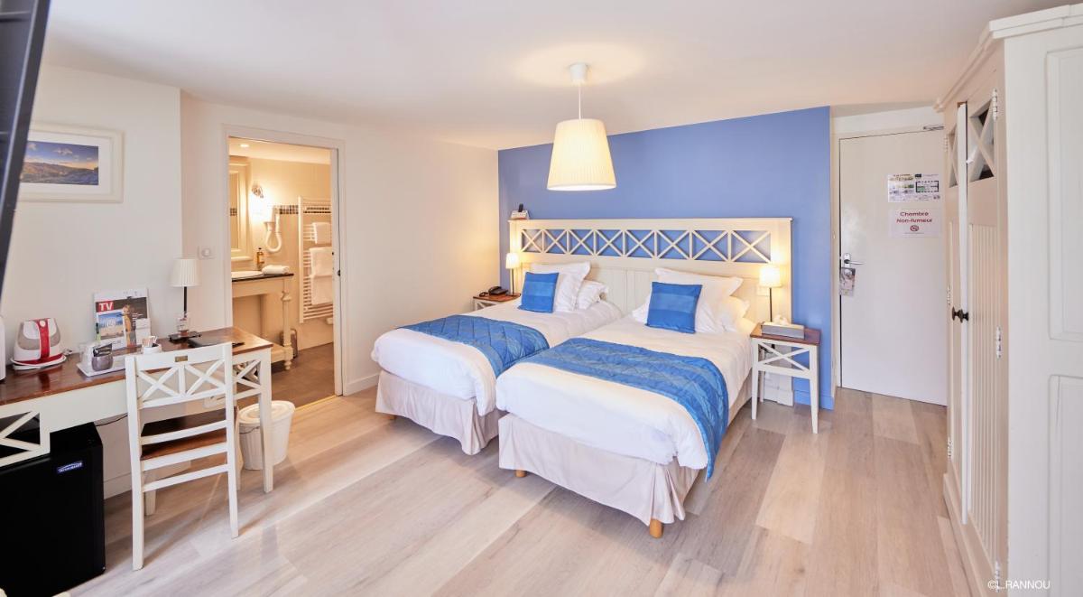 Un ou plusieurs lits dans un hébergement de l'établissement Logis Hotel, restaurant et spa Le Relais De Broceliande