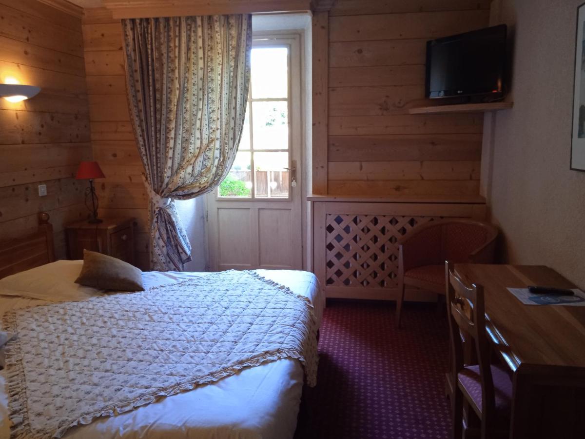 une chambre avec un lit, une fenêtre et une table dans l'établissement Hotel les Sapins, à La Clusaz