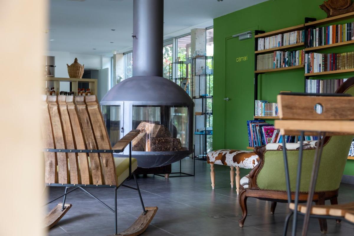 - un salon avec une cheminée et des étagères dans l'établissement Artemisia Boutique Hotel, à Bastelica
