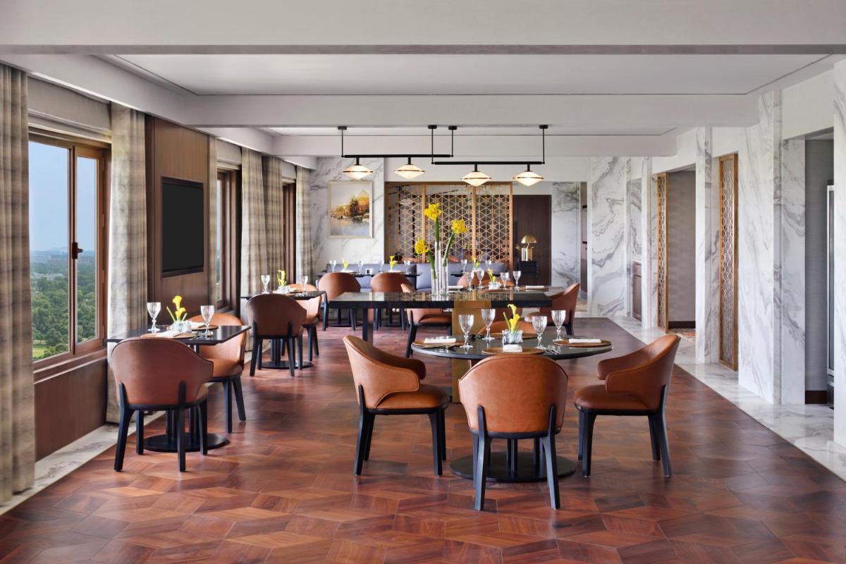 a restaurant with tables and chairs in a room at Taj Mahal, New Delhi in New Delhi