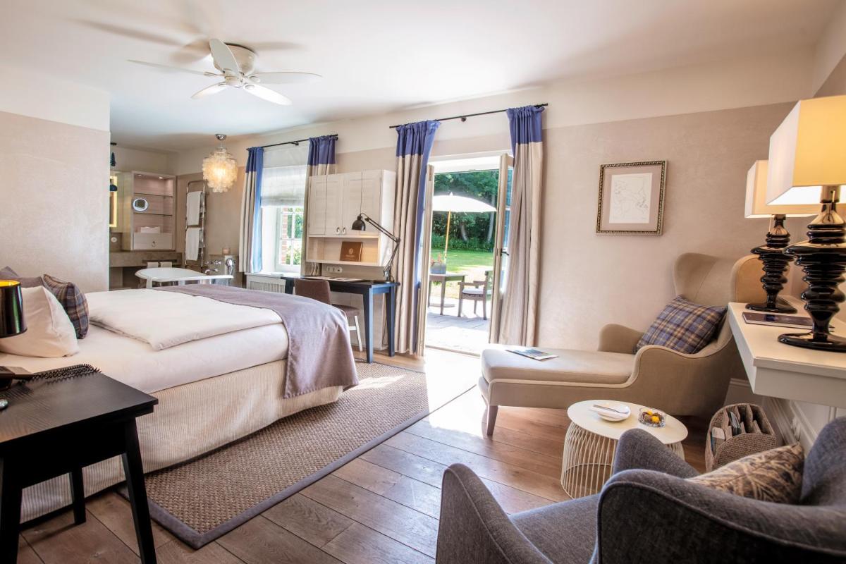 ein Schlafzimmer mit Bett und ein Wohnzimmer in der Unterkunft Weissenhaus Private Nature Luxury Resort in Weißenhaus