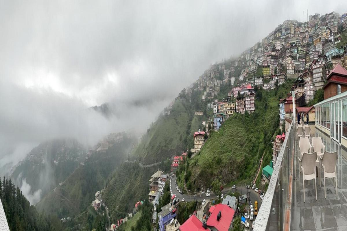 a view of a mountain with a town on it at The Orchid Shimla in Shimla