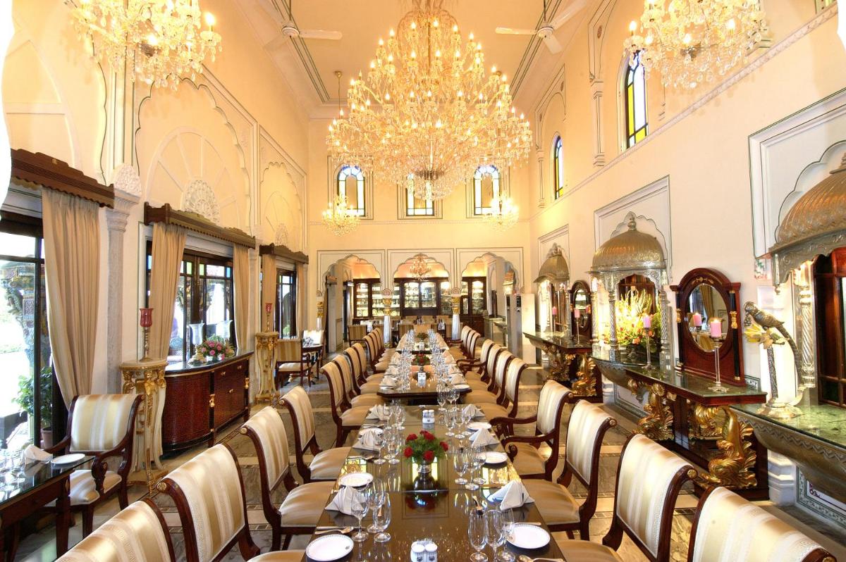 a long dining room with long tables and chairs at The Raj Palace (Small Luxury Hotels of the World) in Jaipur
