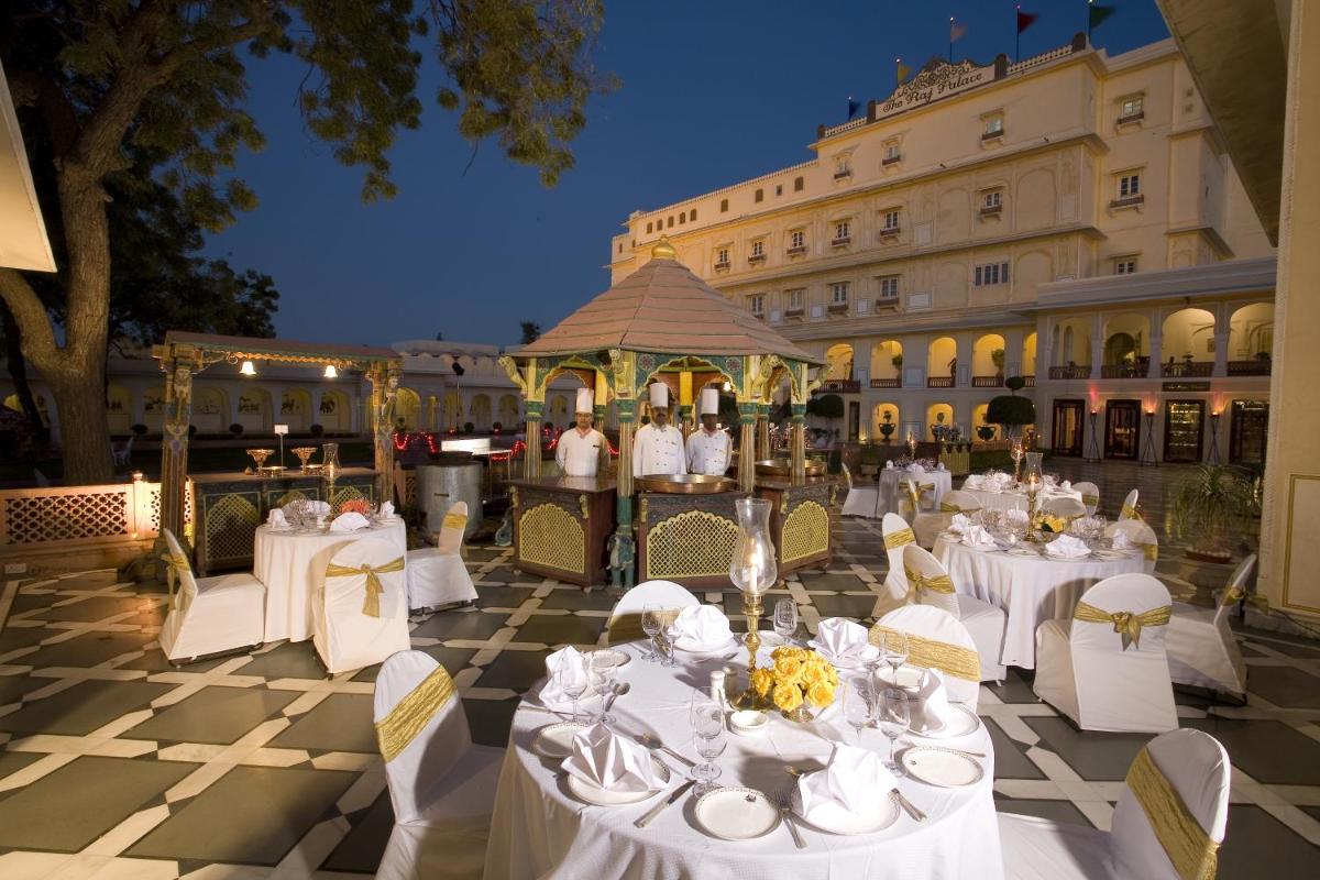 a marquee with white tables and chairs and a building at The Raj Palace (Small Luxury Hotels of the World) in Jaipur