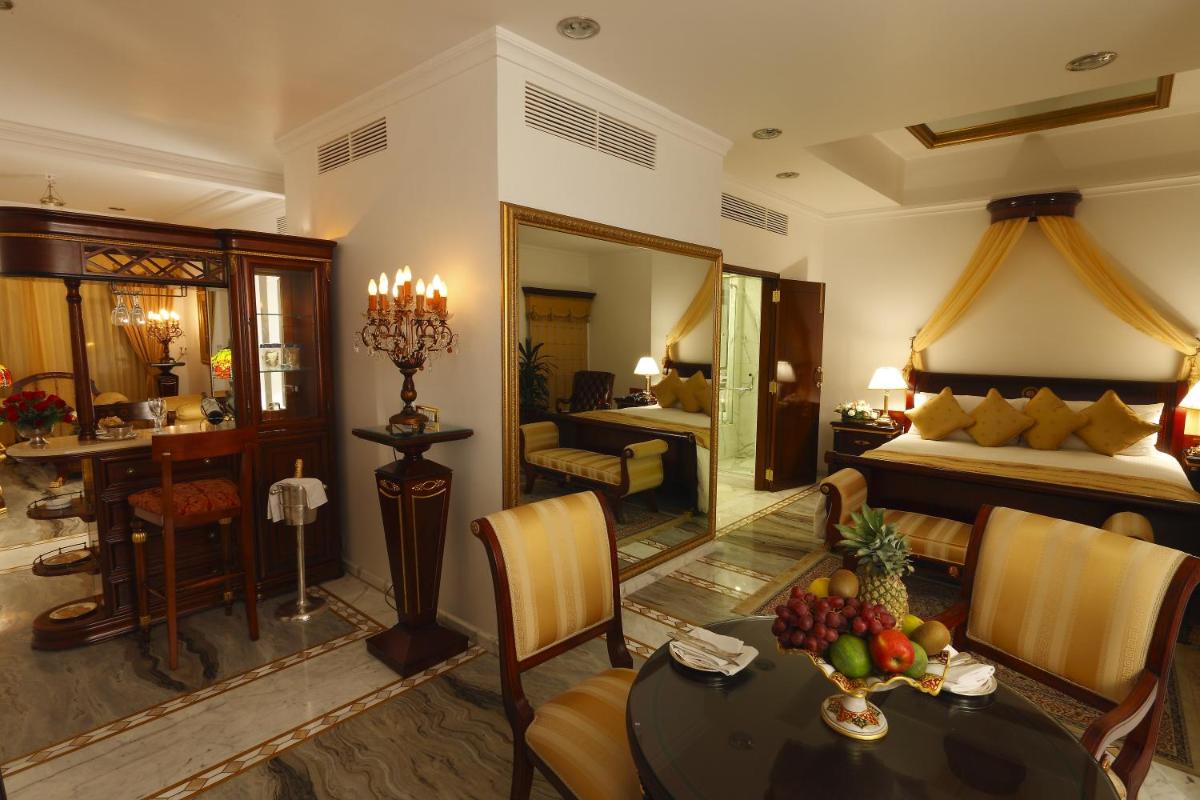 a living room with a bed and a table with fruit on it at The Raj Palace (Small Luxury Hotels of the World) in Jaipur