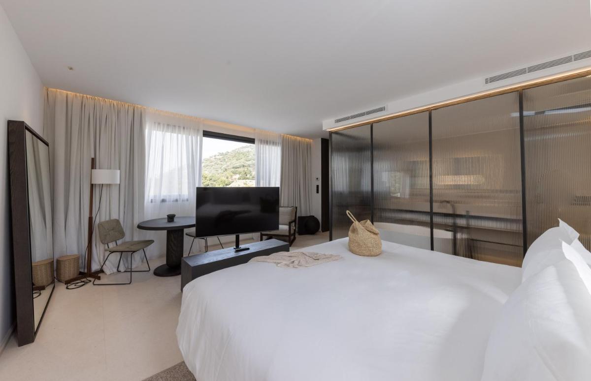 une chambre d'hôtel avec un grand lit blanc et un bureau dans l'établissement Casa Paradisu, à LʼÎle-Rousse