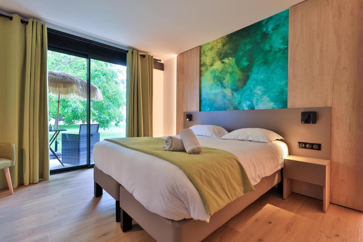 une chambre avec un grand lit et un grand tableau au mur dans l'établissement Logis Hôtel & Spa Déjeunez Sous L'Arbre, à Rousset 87 autres photos