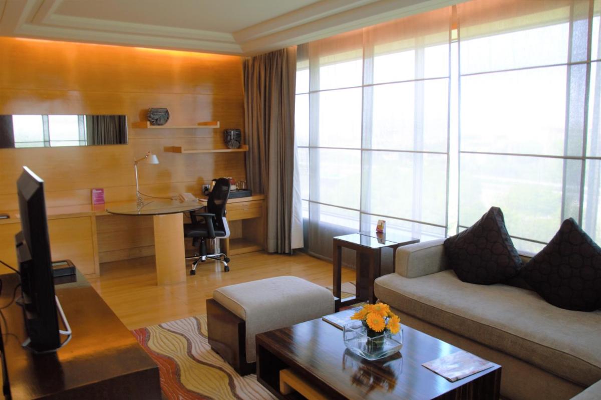 a living room with a couch and a desk at Crowne Plaza Today Gurugram by IHG in Gurgaon