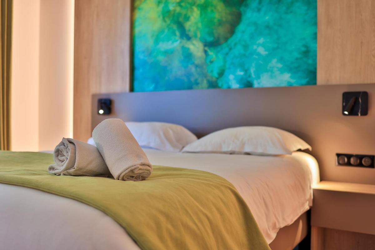 Un ou plusieurs lits dans un hébergement de l'établissement Logis Hôtel & Spa Déjeunez Sous L'Arbre