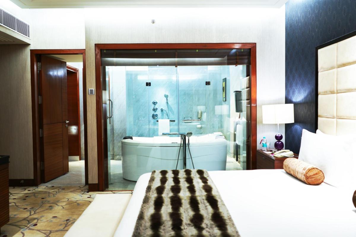 a bedroom with a bathroom with a tub and a sink at Crowne Plaza Today Gurugram by IHG in Gurgaon