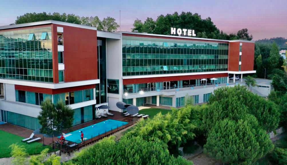 um hotel com piscina em frente a um prédio em Penafiel Park Hotel & Spa em Penafiel
