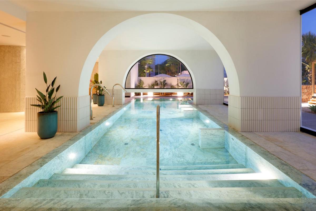 una piscina en un edificio con un arco en TRS Ibiza Hotel - Adults Only, en San Antonio