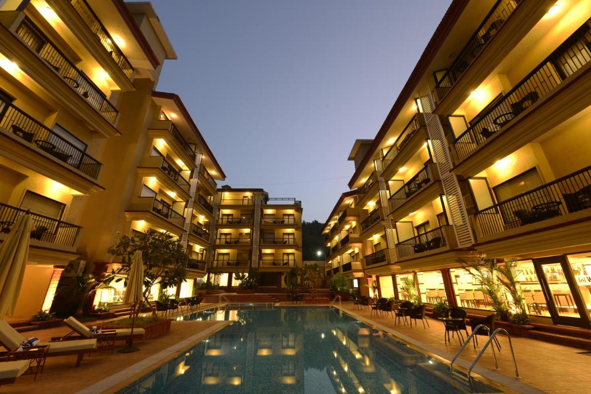 a swimming pool in the middle of a building at Deltin Suites in Candolim
