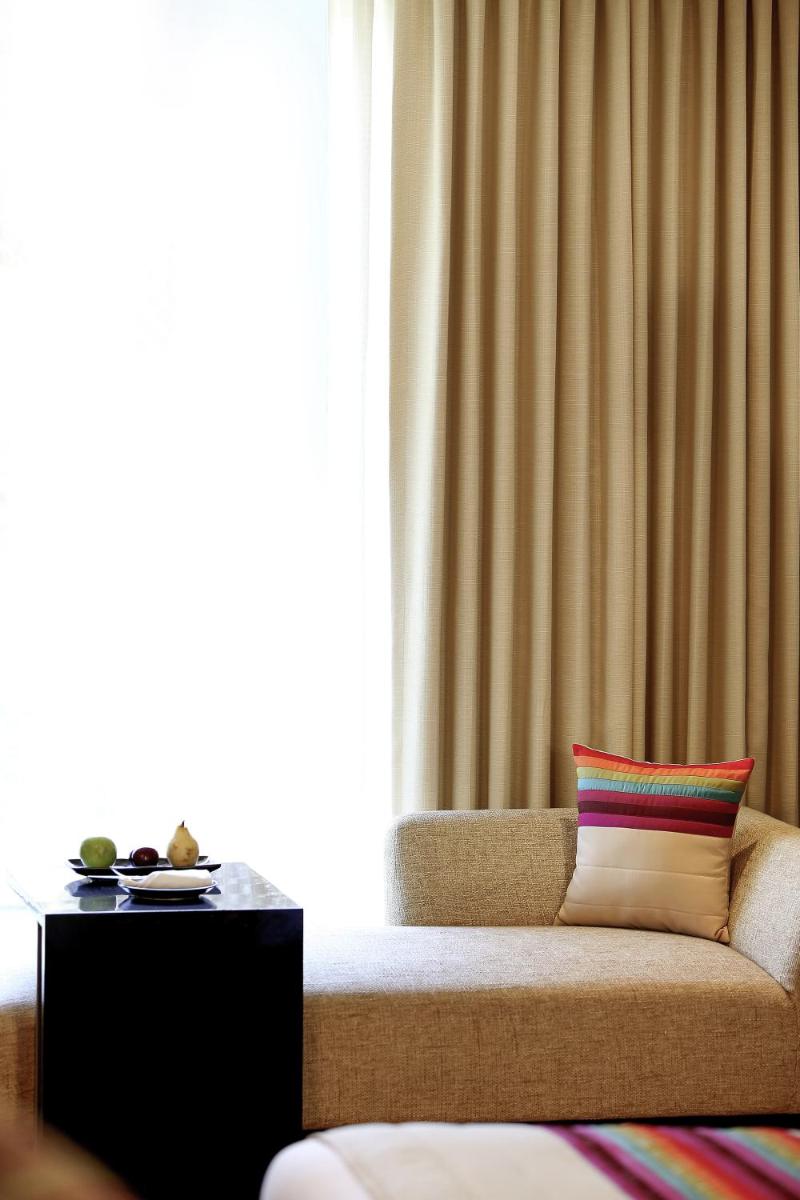 a living room with a couch and a window at Novotel Kolkata Hotel and Residences in Kolkata a living room with a couch and a window at Novotel Kolkata Hotel and Residences in Kolkata