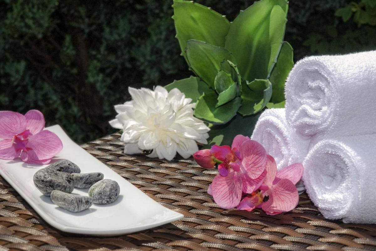 a table with towels towels and rocks and flowers at Novotel Kolkata Hotel and Residences in Kolkata a table with towels towels and rocks and flowers at Novotel Kolkata Hotel and Residences in Kolkata