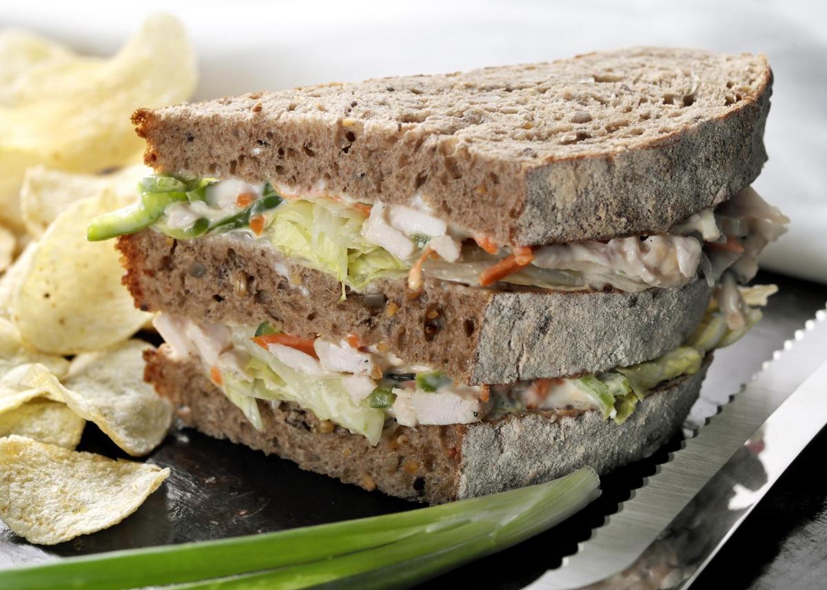 a sandwich cut in half on a plate with chips at Novotel Kolkata Hotel and Residences in Kolkata a sandwich cut in half on a plate with chips at Novotel Kolkata Hotel and Residences in Kolkata
