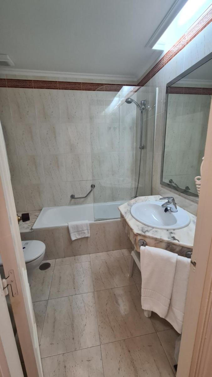 Un baño con lavabo, bañera e inodoro. en Hotel Las Sirenas, en Viveiro
