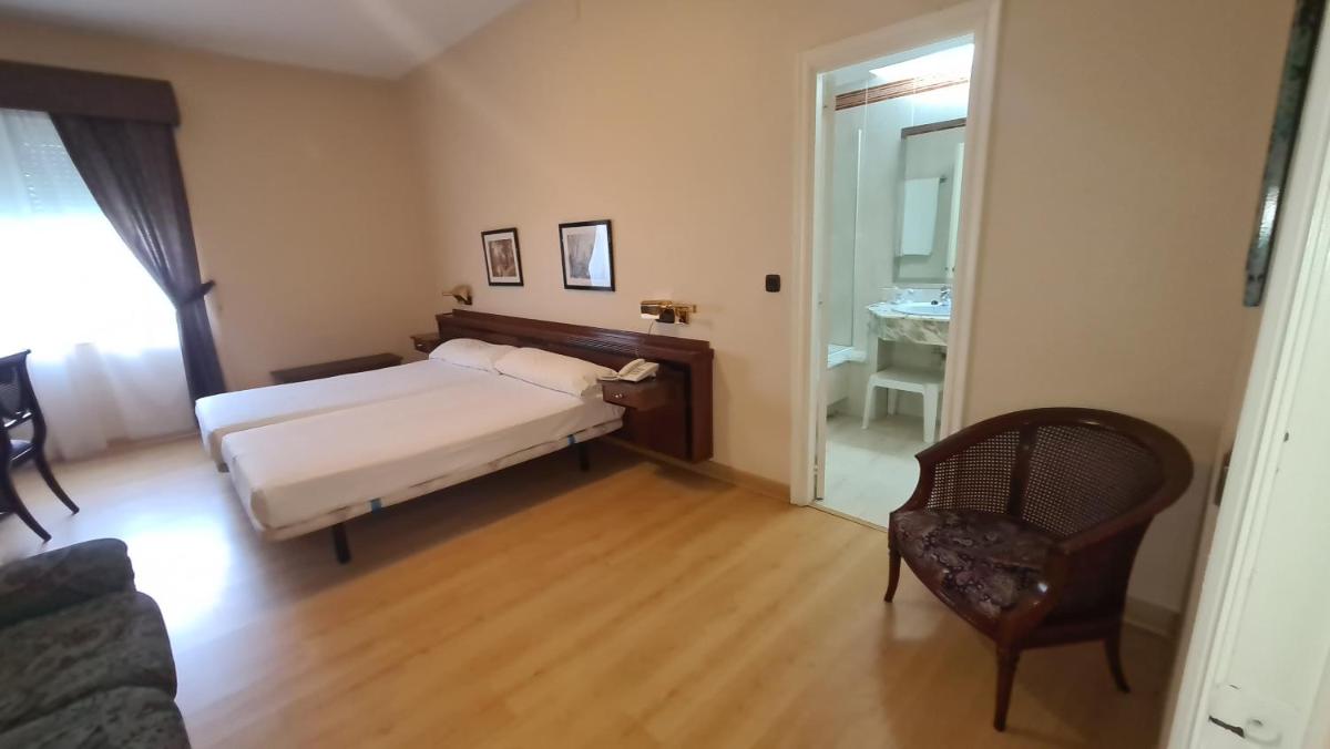 un dormitorio con una cama y una silla en Hotel Las Sirenas, en Viveiro 11 fotos más