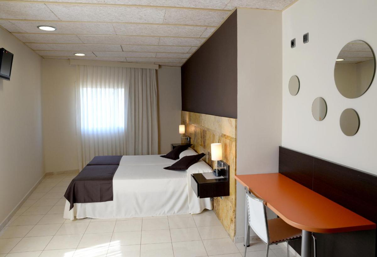 una habitación de hotel con una cama y un escritorio en Hotel Spa Pinar del Mar, en Platja d'Aro