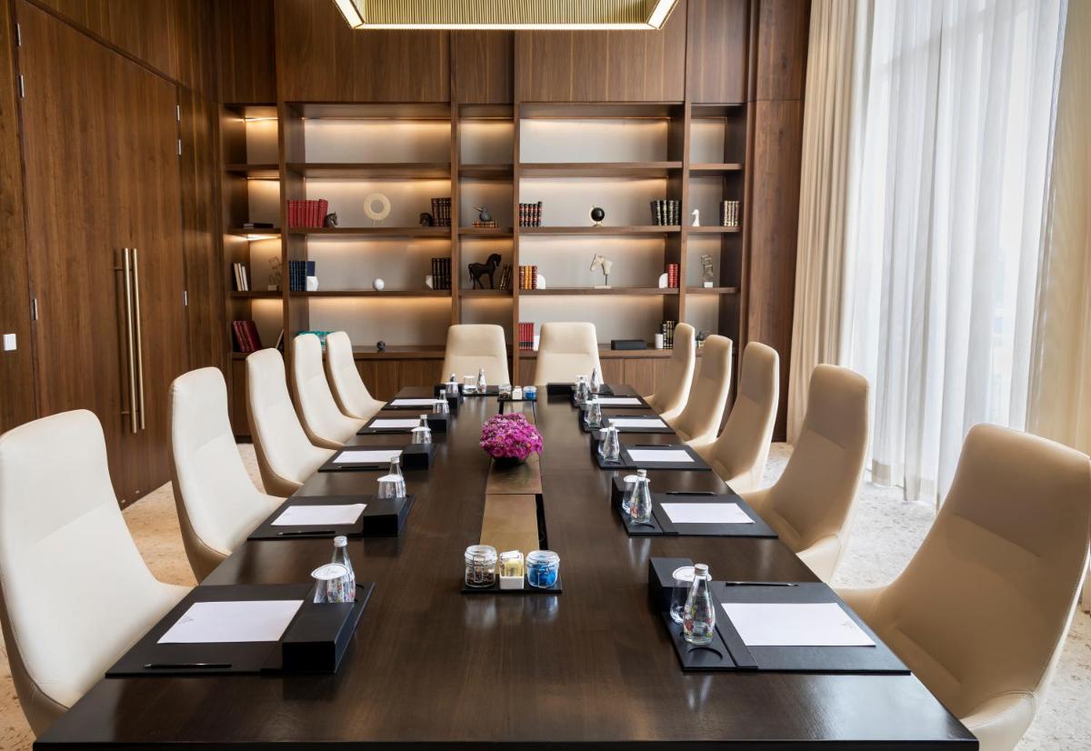 a conference room with a long table and chairs at The Leela Bhartiya City Bengaluru in Bengaluru a conference room with a long table and chairs at The Leela Bhartiya City Bengaluru in Bengaluru