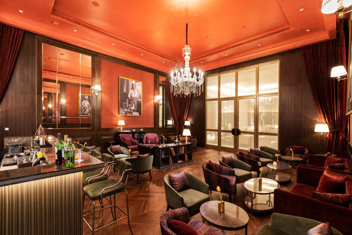 a restaurant with couches and tables and a chandelier at The Leela Bhartiya City Bengaluru in Bengaluru a restaurant with couches and tables and a chandelier at The Leela Bhartiya City Bengaluru in Bengaluru