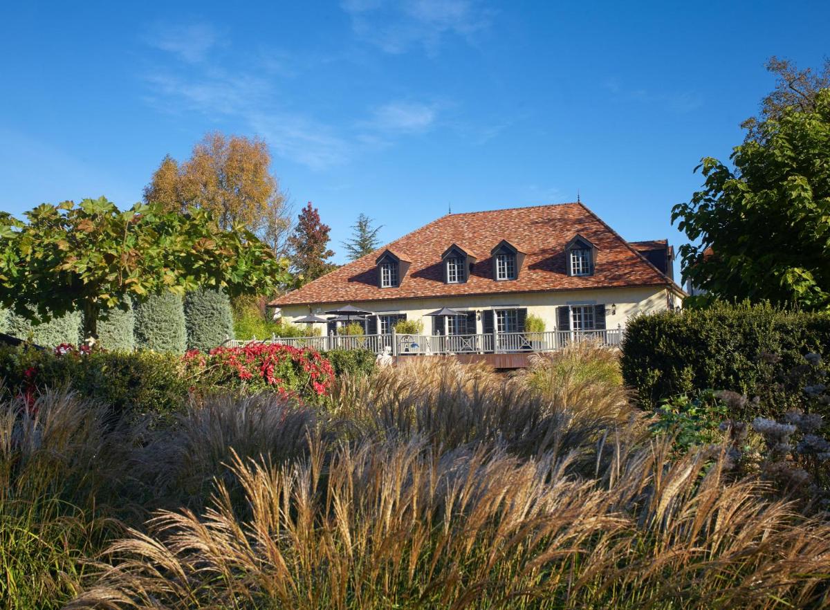 une maison avec un toit dans un jardin dans l'établissement Chateau De Germigney, à Port-Lesney