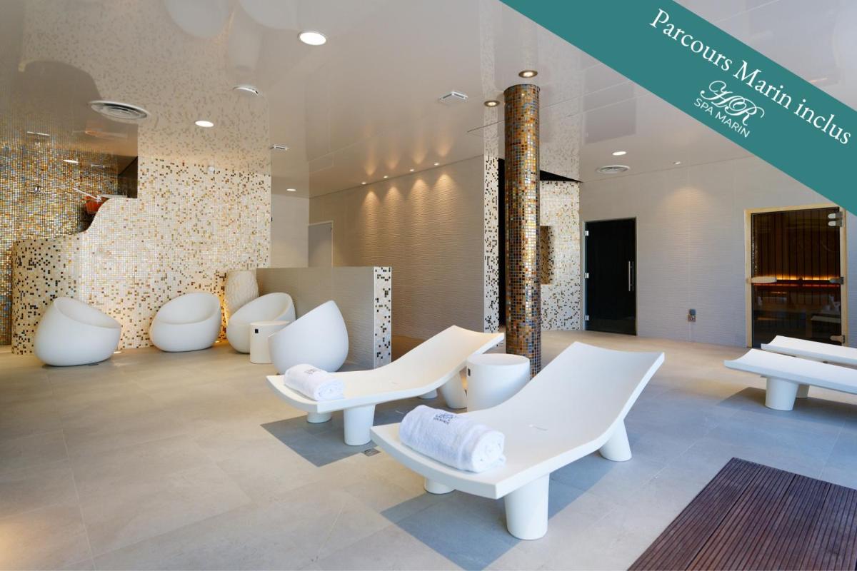 une salle d'attente avec des chaises blanches et un mur dans l'établissement HR Hôtel-Restaurant & Spa Marin, à La Flotte une salle d'attente avec des chaises blanches et un mur dans l'établissement HR Hôtel-Restaurant & Spa Marin, à La Flotte