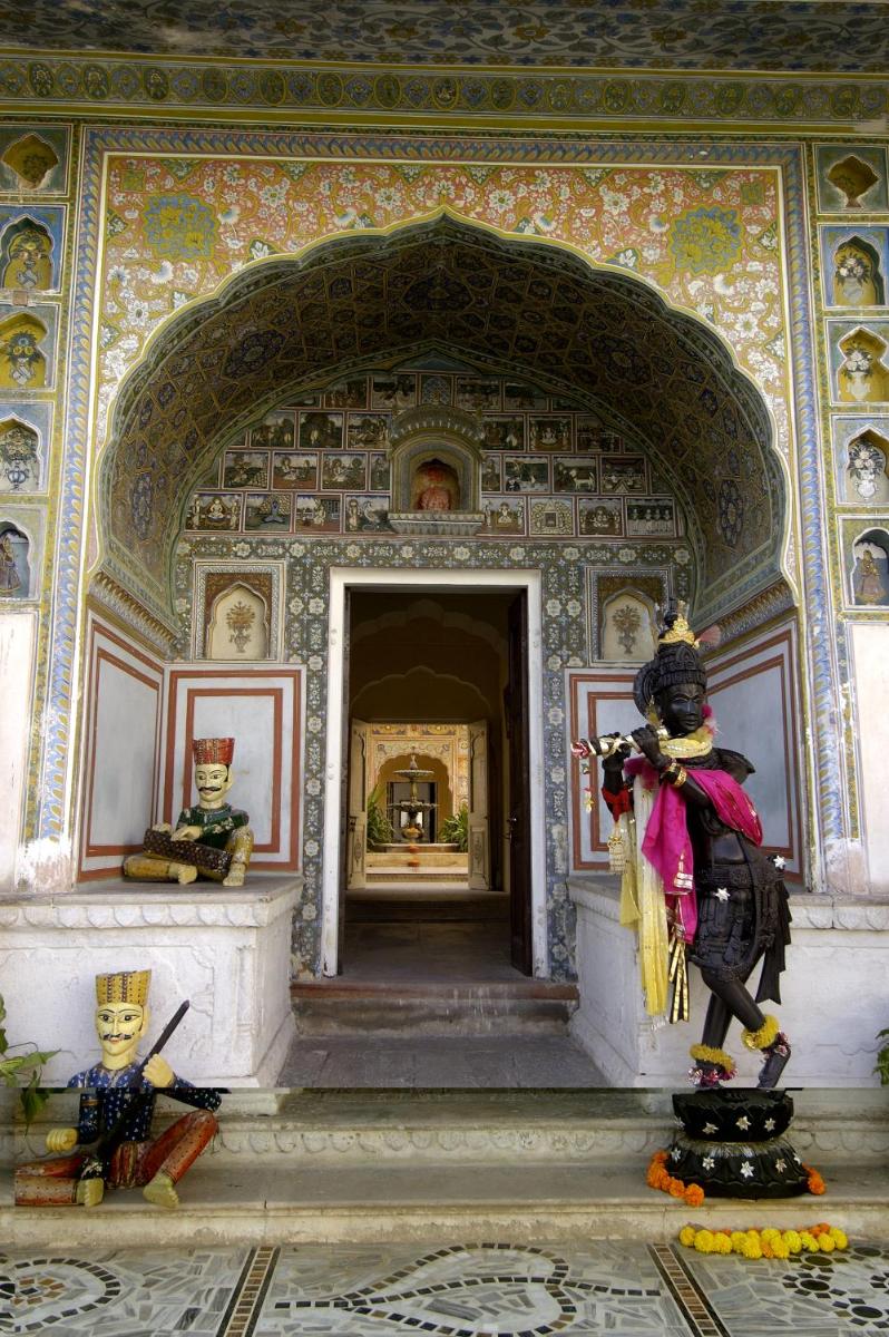 a room with a statue of a person in a building at The Raj Palace (Small Luxury Hotels of the World) in Jaipur