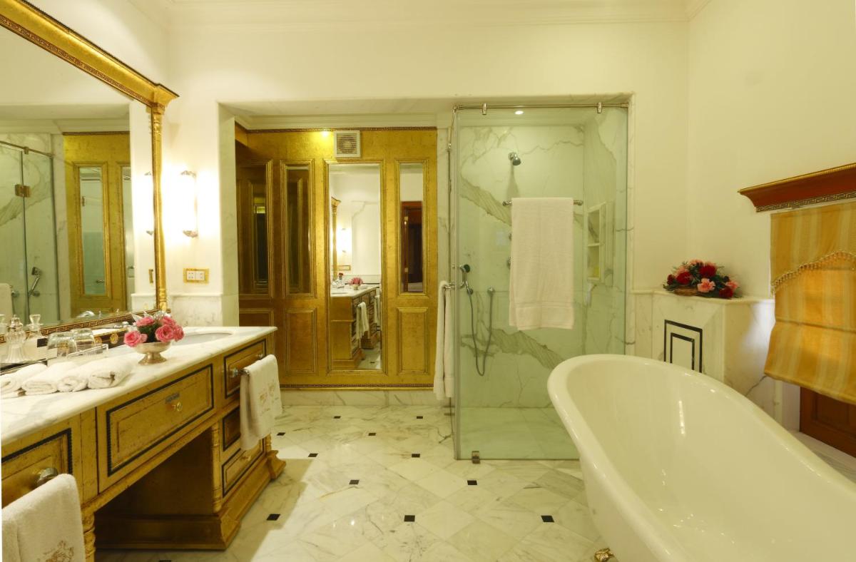 a bathroom with a tub and a shower and a sink at The Raj Palace (Small Luxury Hotels of the World) in Jaipur