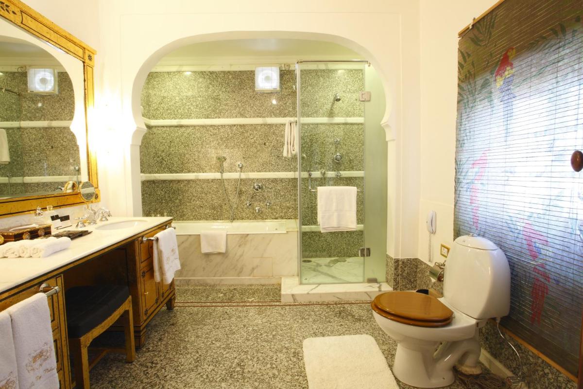 a bathroom with a shower and a toilet and a sink at The Raj Palace (Small Luxury Hotels of the World) in Jaipur