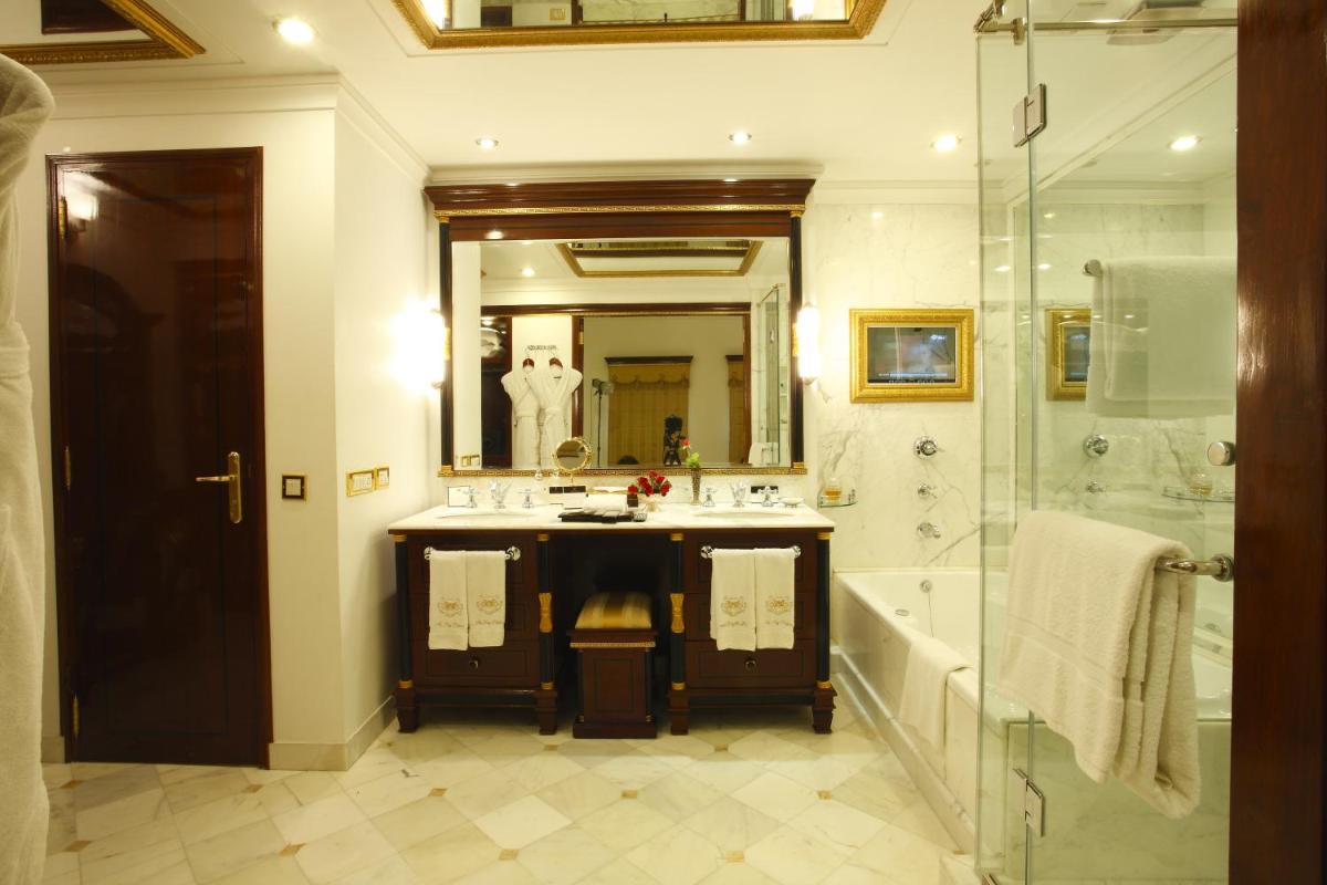 a bathroom with a tub and a sink and a shower at The Raj Palace (Small Luxury Hotels of the World) in Jaipur