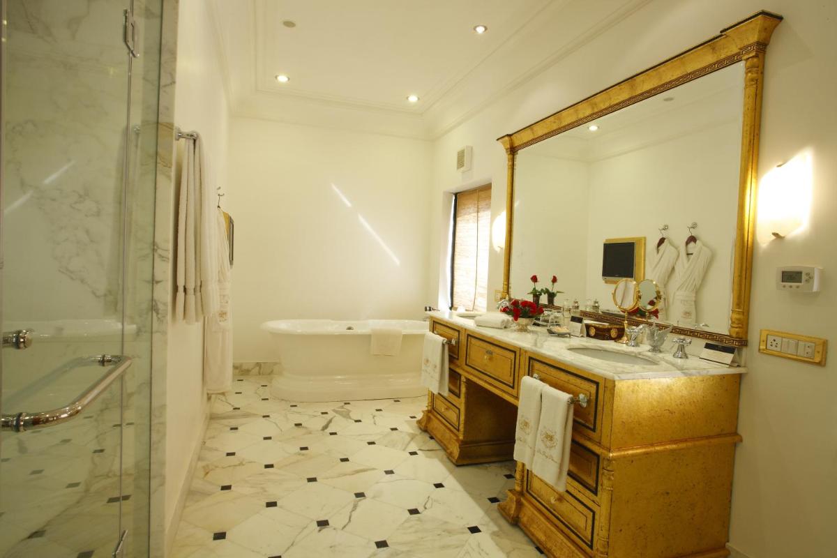 a bathroom with a tub and a sink and a mirror at The Raj Palace (Small Luxury Hotels of the World) in Jaipur
