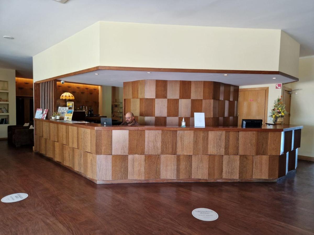 Um homem sentado num balcão na entrada. em Hotel Da Montanha em Pedrógão Pequeno mais 124 fotografias