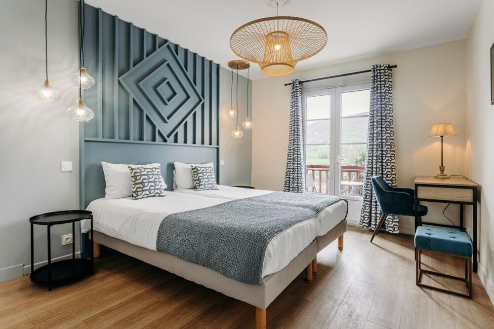 une chambre avec un lit, un bureau et une fenêtre dans l'établissement Hotel Restaurant du Fronton - Maison Bonnet, à Itxassou
