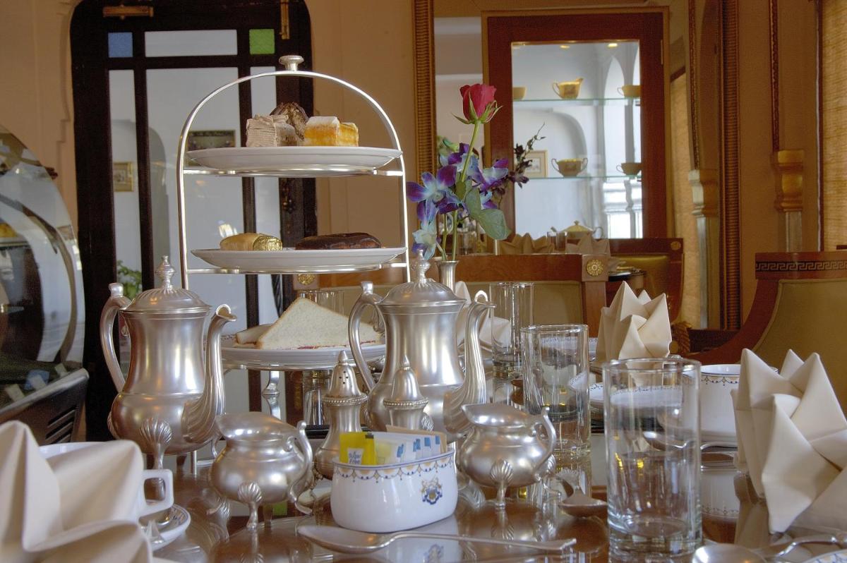 a table with glasses and jars and dishes on it at The Raj Palace (Small Luxury Hotels of the World) in Jaipur