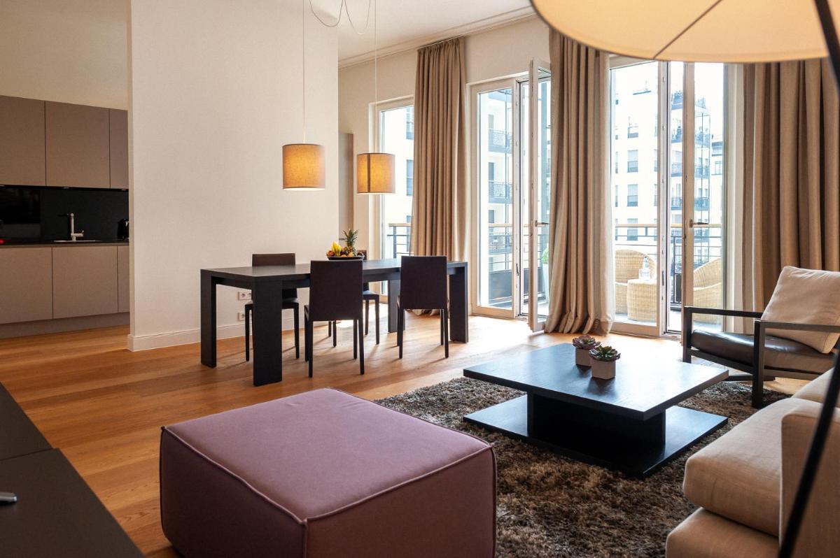 ein Wohnzimmer mit Tisch und Couch in der Unterkunft The Wellem Residences in Düsseldorf