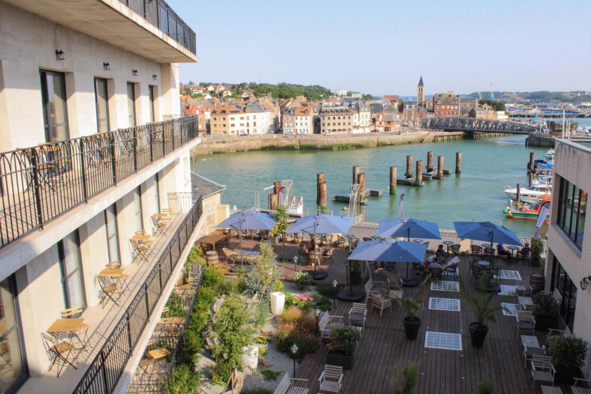 - un balcon avec des tables et des parasols à côté d'une rivière dans l'établissement LA TOUR AUX CRABES près de la plage, à Dieppe