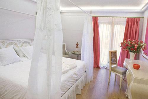 Un dormitorio con una cama blanca y una mesa y un escritorio. en Hotel Sa Calma, en Begur 47 fotos más