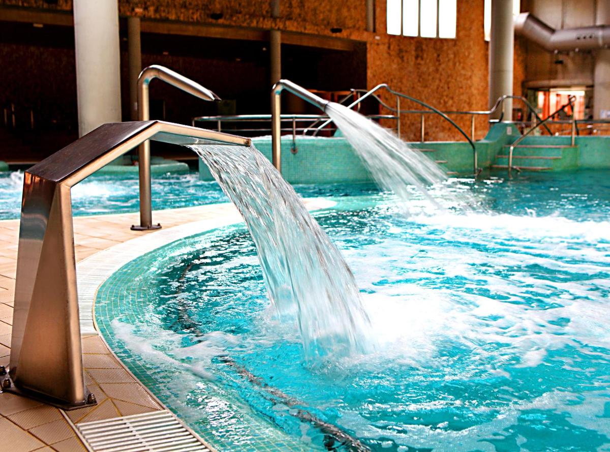 una piscina con una fuente de agua en un edificio en Balneario de Archena - Hotel Termas, en Archena