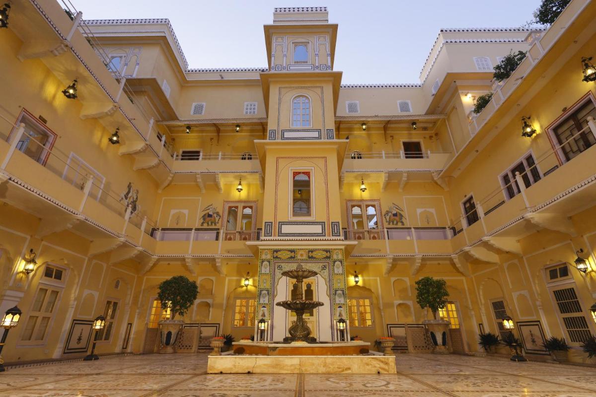 a large building with a fountain in the middle at The Raj Palace (Small Luxury Hotels of the World) in Jaipur