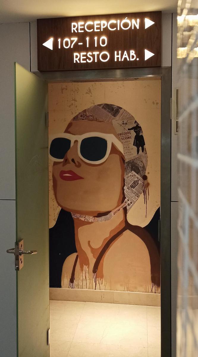 una puerta del ascensor con un cuadro de una mujer con gafas de sol en ARVA Spa París, en León