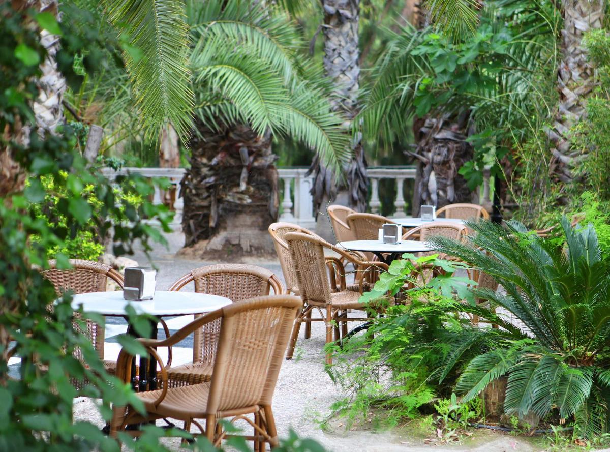 una fila de mesas y sillas en un jardín en Balneario de Archena - Hotel Termas, en Archena