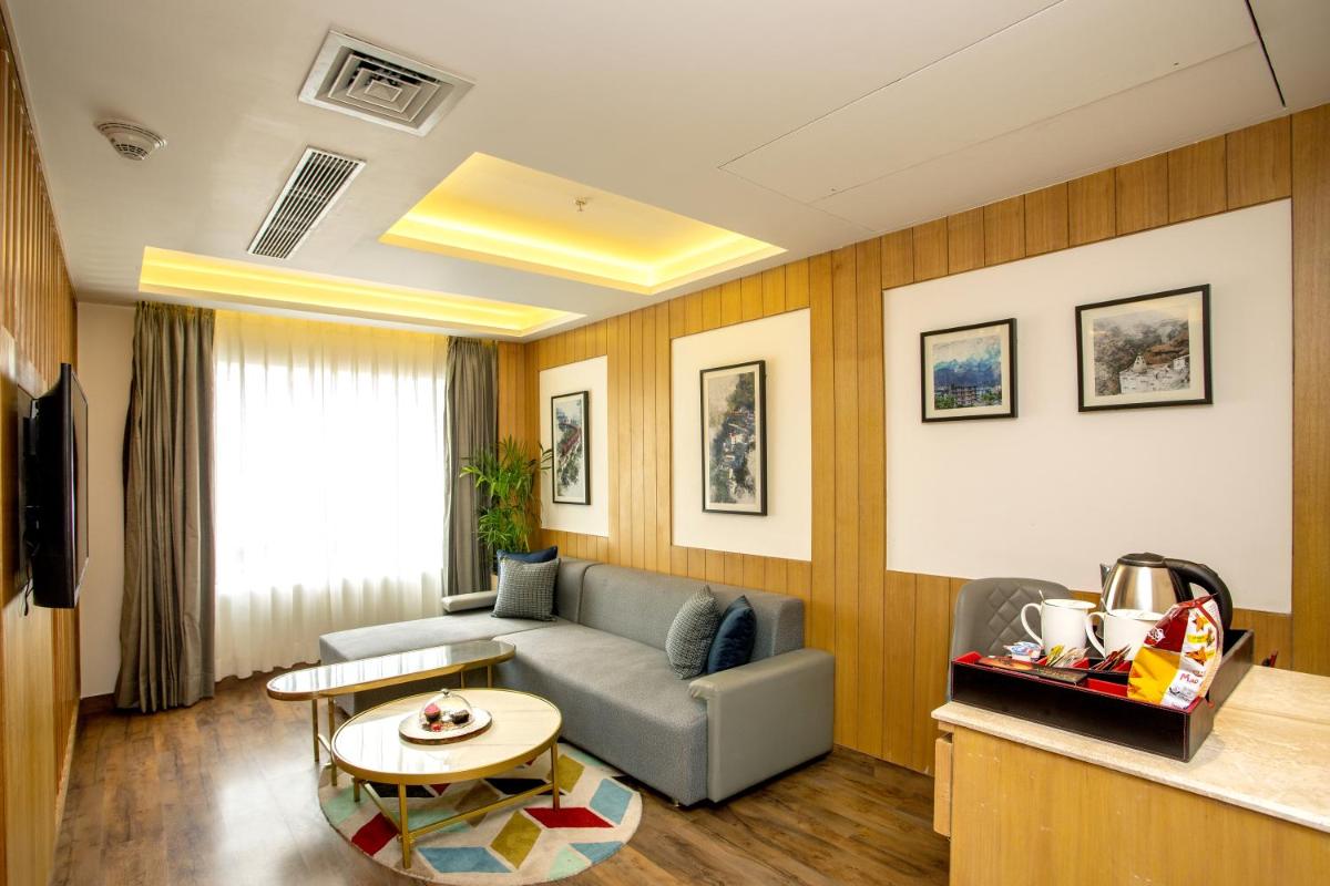 a living room with a couch and a table at Ramada by Wyndham Katra Station Road in Katra