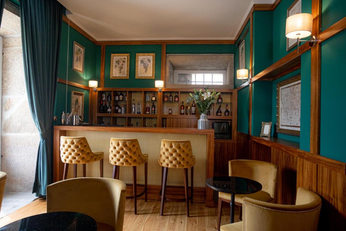 um bar em um restaurante com paredes e cadeiras verdes em Solar do Requeijo by Luna Hotels & Resorts em Arcos de Valdevez