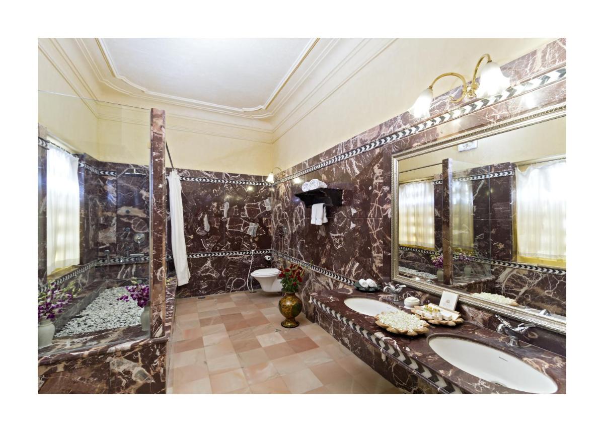 a bathroom with two sinks and a large mirror at Chunda Palace in Udaipur