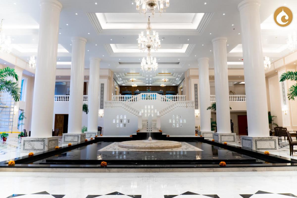 a large lobby with a fountain and a chandelier at Clarks Avadh in Lucknow