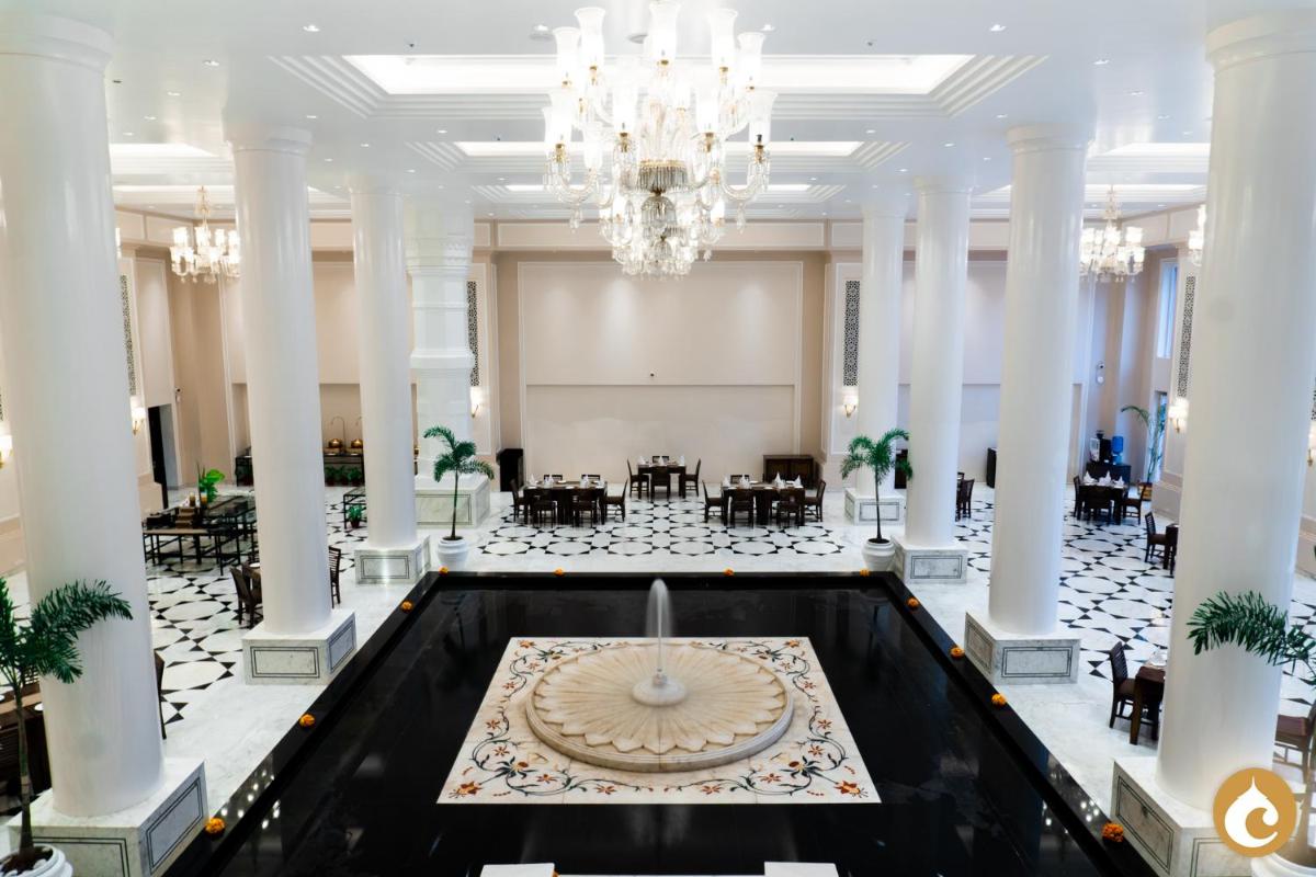 a large lobby with a chandelier and a fountain at Clarks Avadh in Lucknow