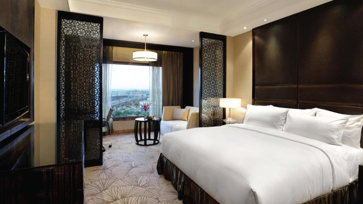 a bedroom with a large bed and a large window at Crowne Plaza New Delhi Mayur Vihar Noida by IHG in New Delhi