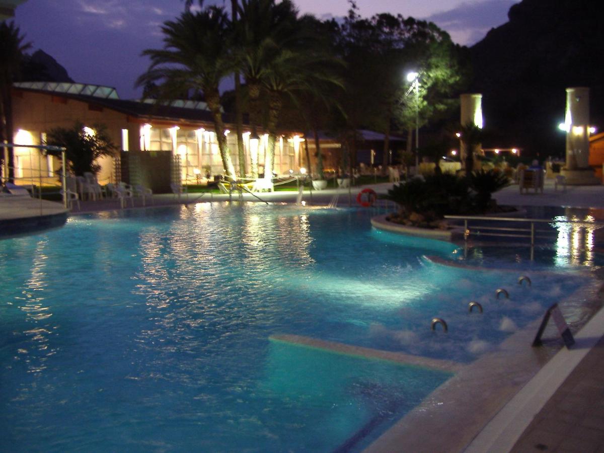 Una piscina de noche con patos en el agua. en Balneario de Archena - Hotel León, en Archena