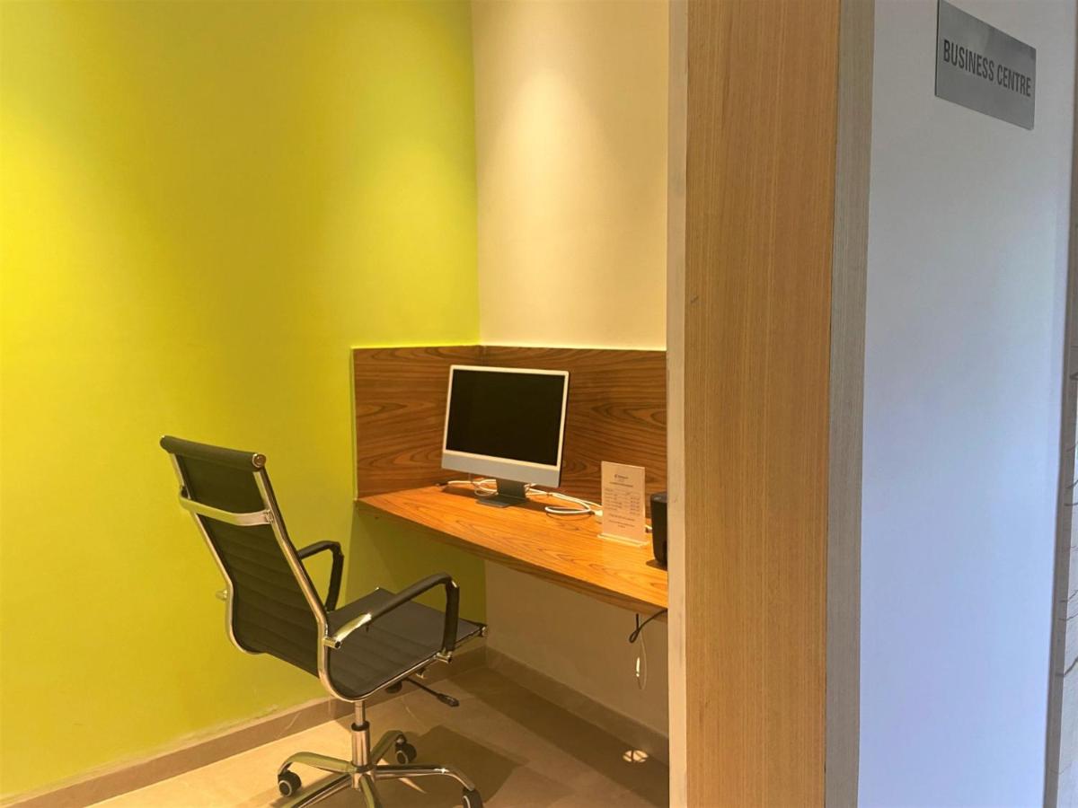a computer sitting on a desk with a chair at Holiday Inn Goa Candolim in Candolim a computer sitting on a desk with a chair at Holiday Inn Goa Candolim in Candolim
